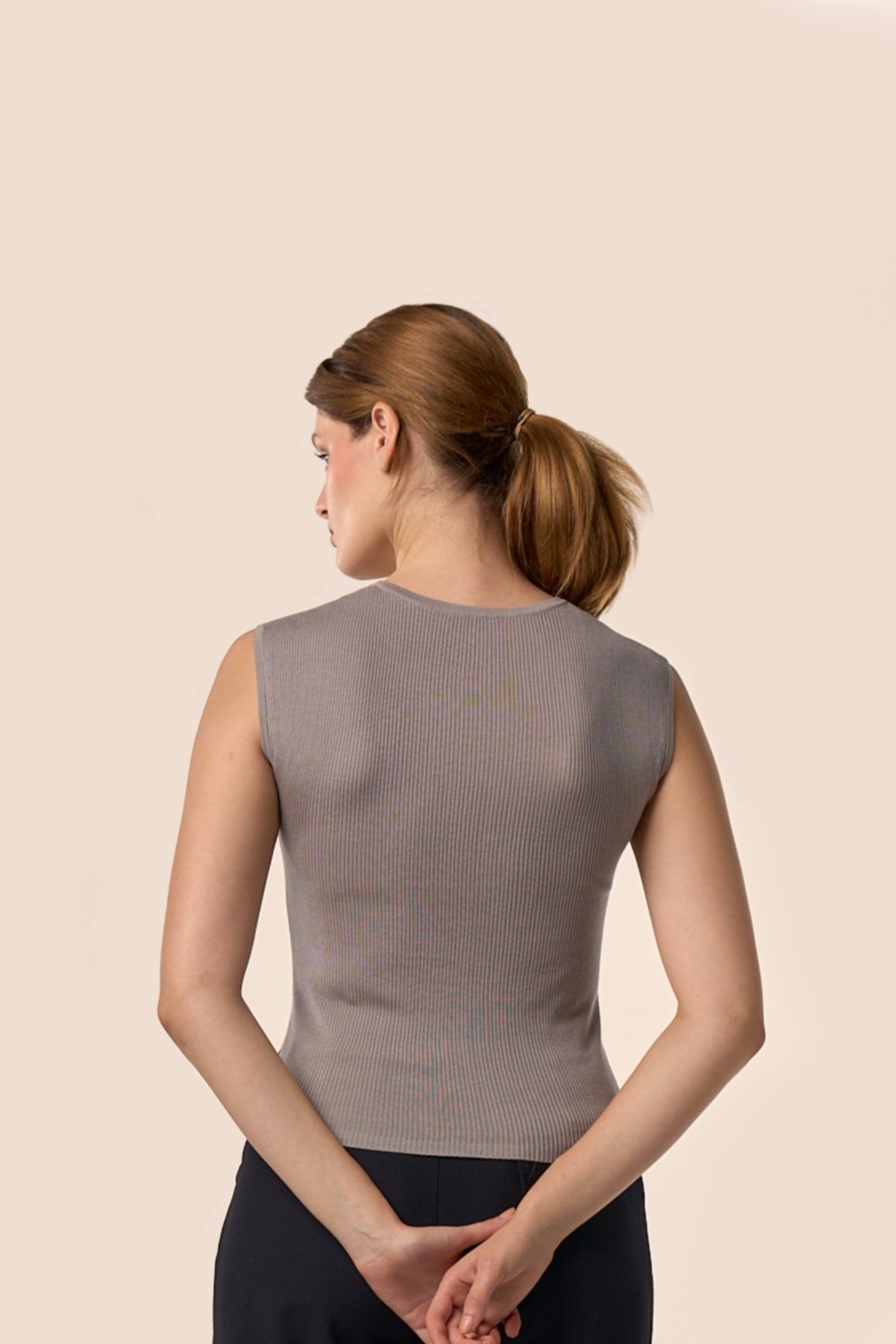 Dos du top gris taupe sans manches en maille côtelée, coupe ajustée, porté avec un pantalon noir — Pote aux Roses Paris