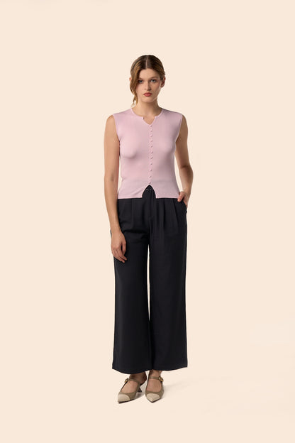 Top rose pâle sans manches en maille côtelée, encolure légèrement ouverte et boutons ton sur ton, porté avec un pantalon noir large — Pote aux Roses Paris