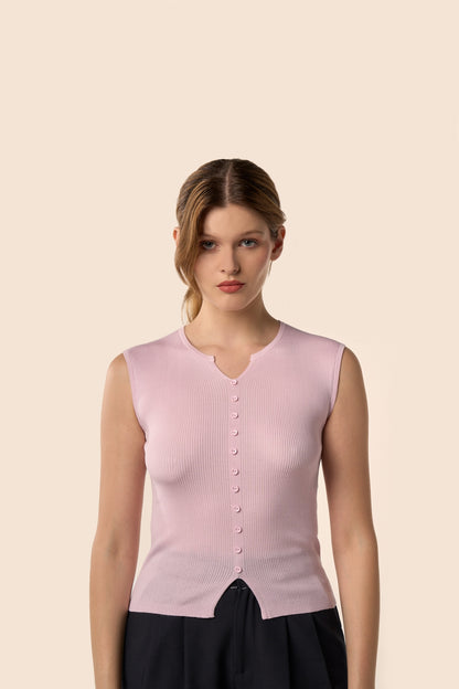 Top rose pâle sans manches en maille côtelée, encolure légèrement ouverte et boutons ton sur ton, porté avec un pantalon noir — Pote aux Roses Paris