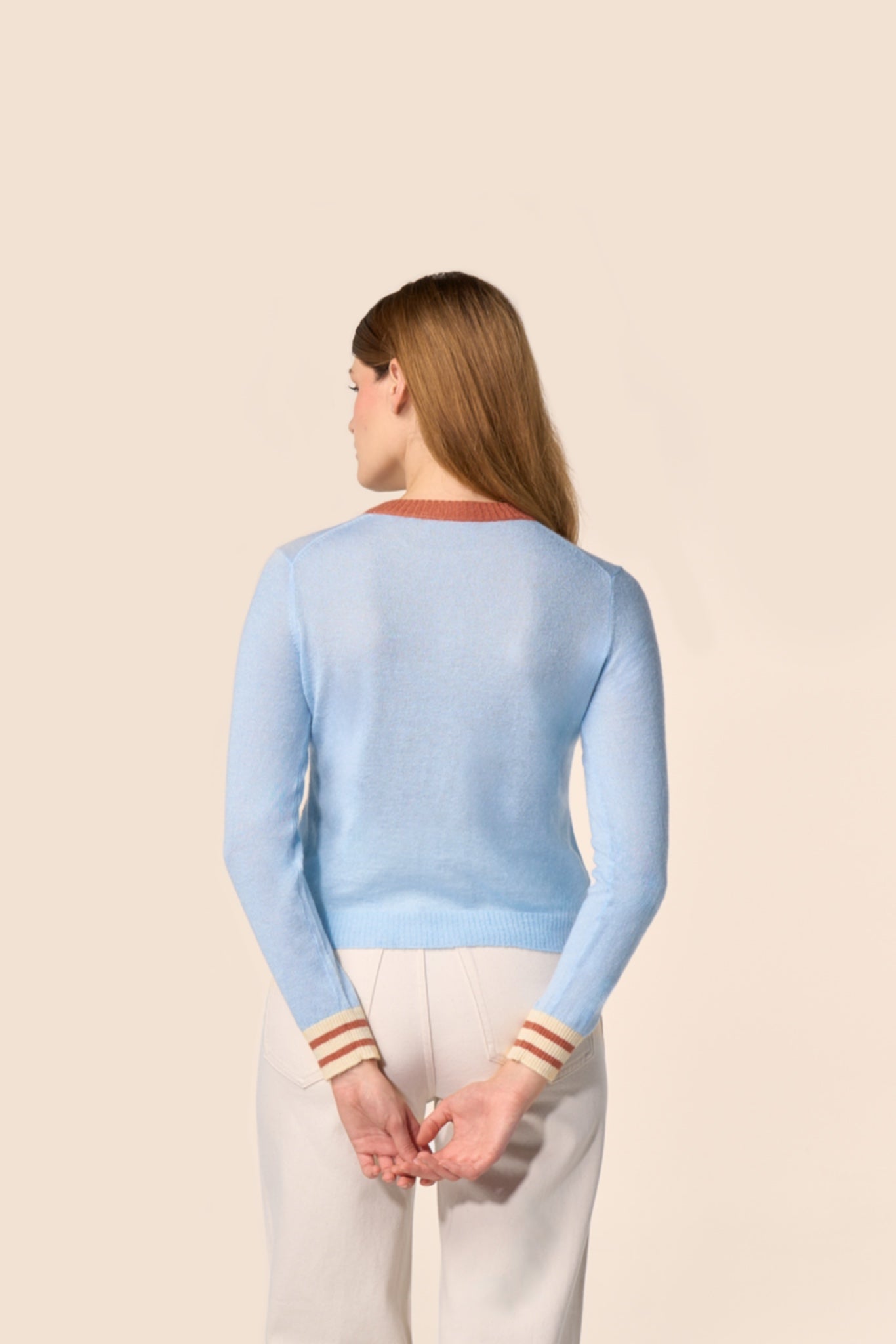 Dos du cardigan bleu ciel en maille, manches longues, col contrasté terracotta et poignets rayés — Pote aux Roses Paris