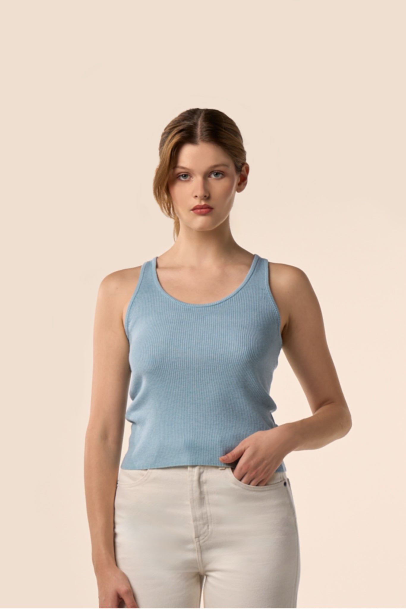 Top sans manches bleu ciel en maille côtelée à encolure ronde, vu de profil, porté avec un pantalon blanc - Pote aux Roses Paris